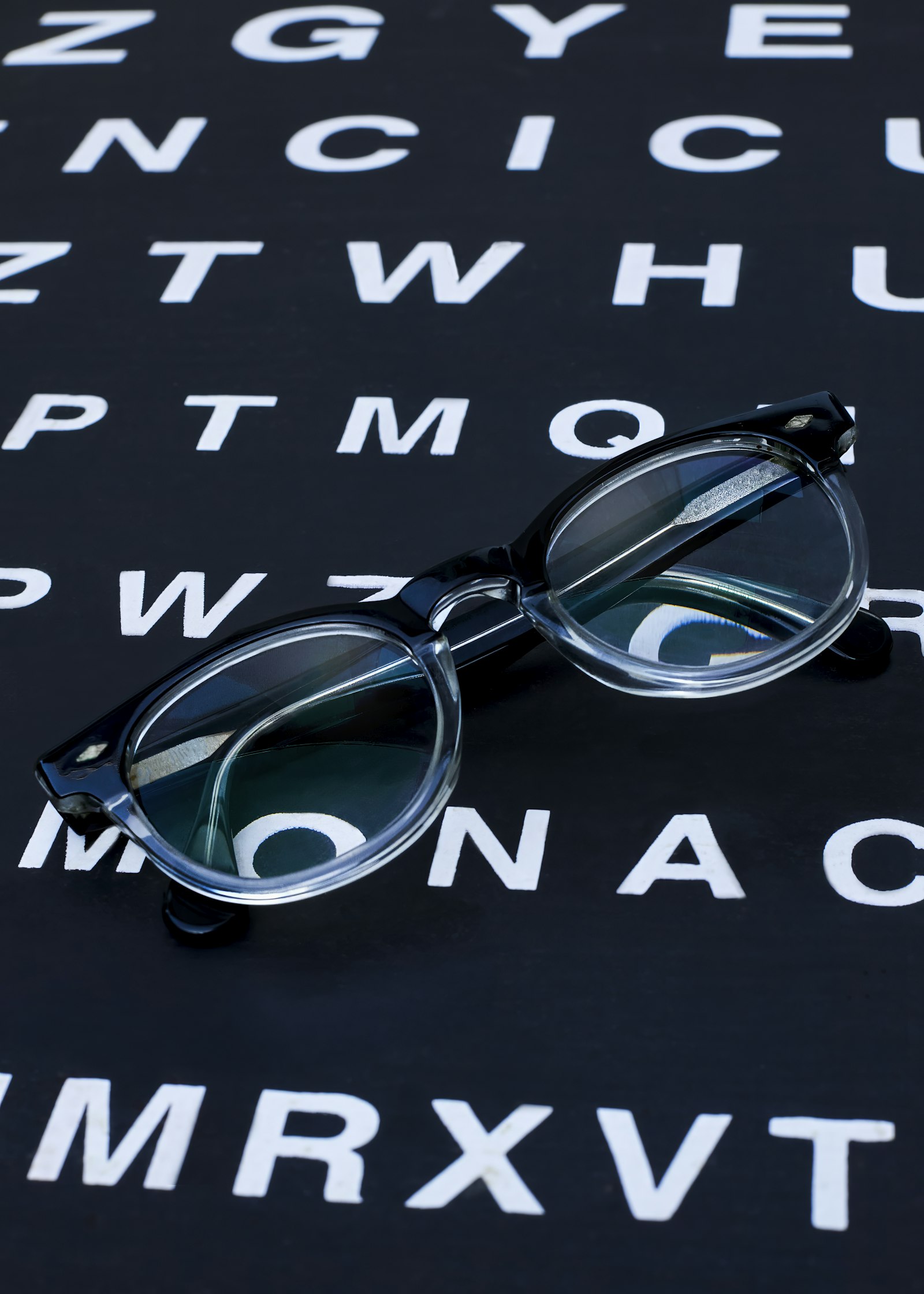 A pair of eyeglasses resting on an eye examination chart